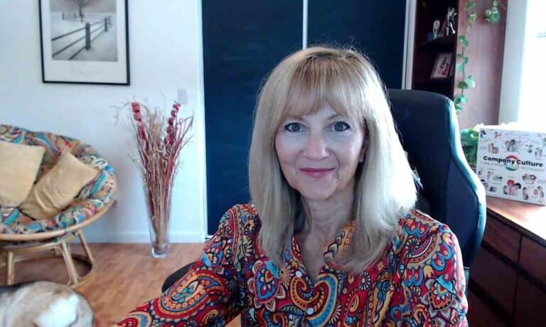 Photo of Stephanie Angelo sitting at her desk smiling at reader.